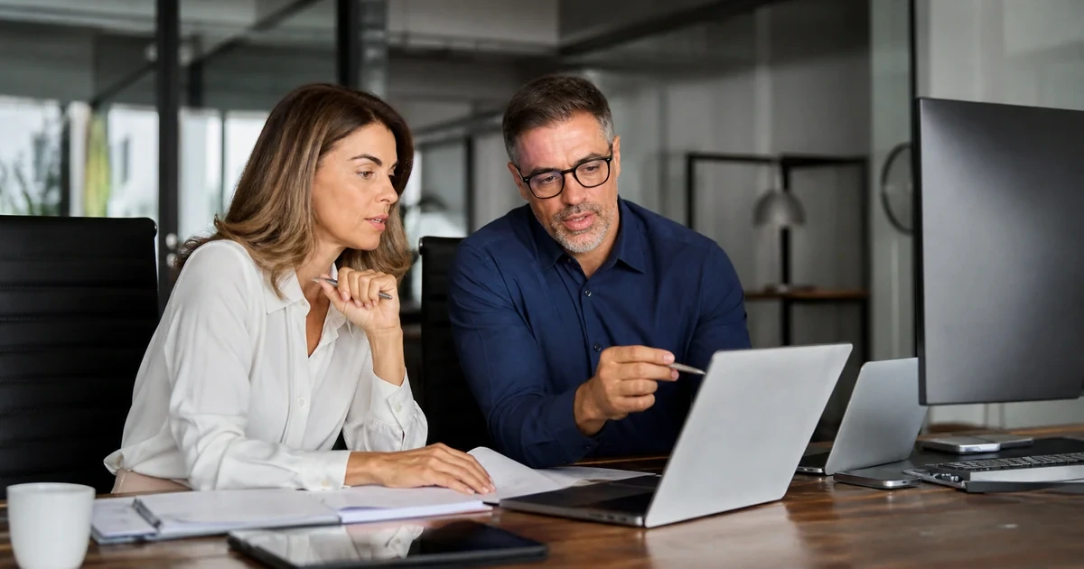 A finance leader and IT manager reconciling a software license inventory with renewal quotes, assigned users, usage evidence, and budget priorities